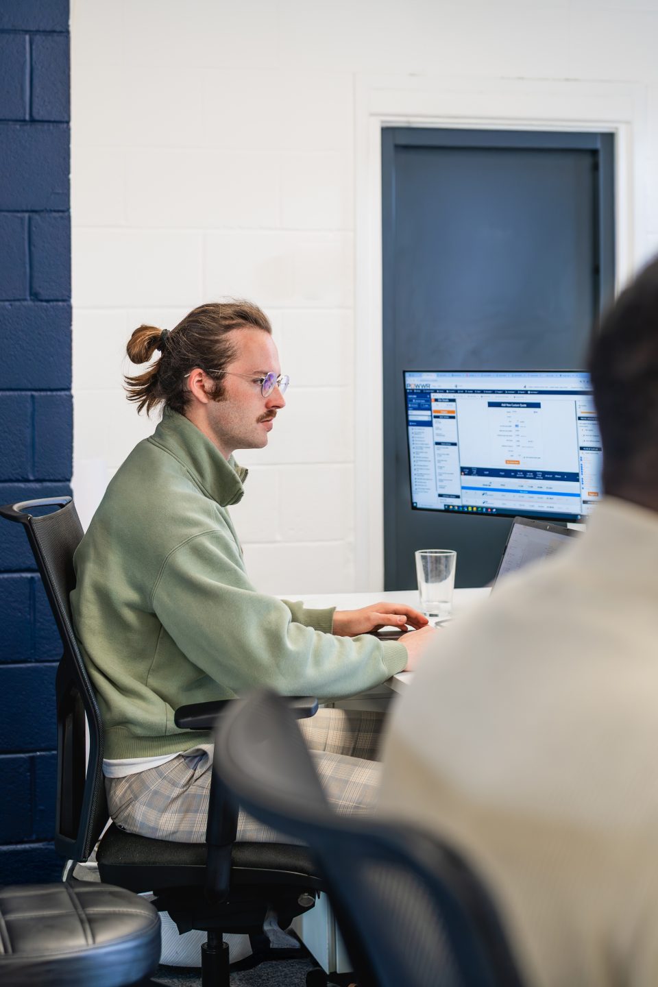 Two people working in an office on their desks