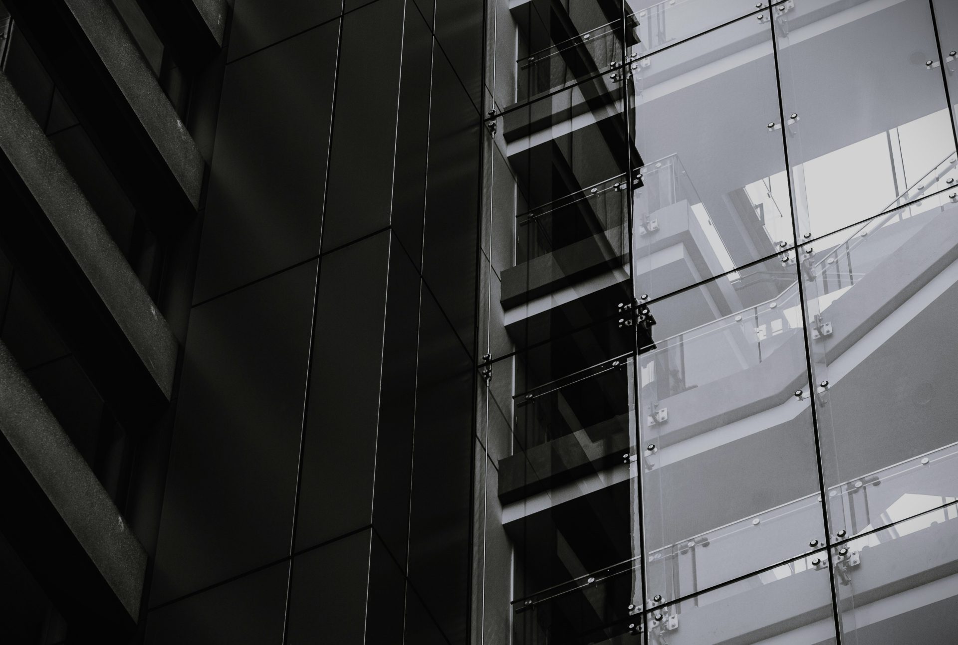 A dark image of a tall building showcasing its windows and the side of the structure.