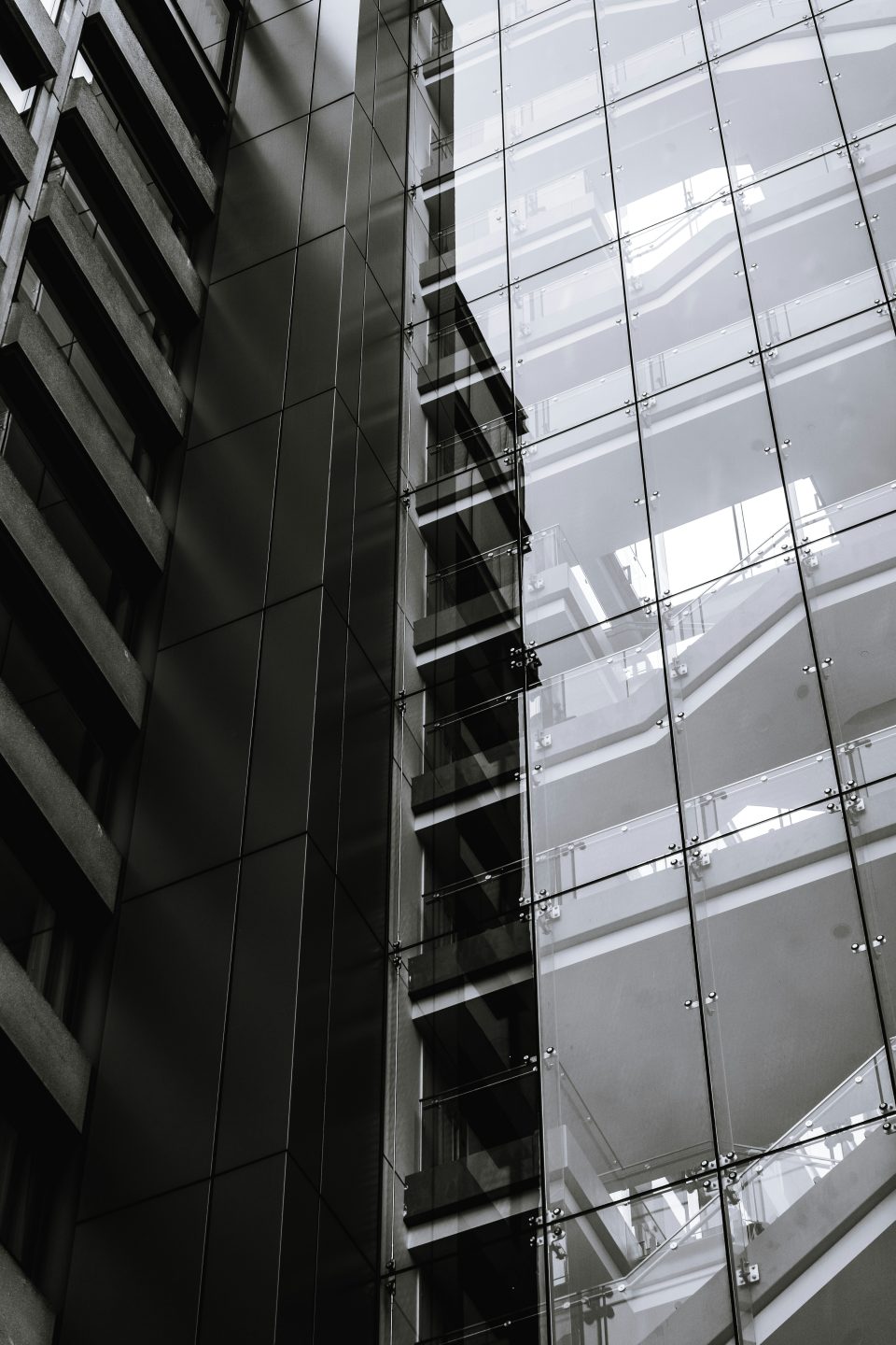 A dark image of a tall building showcasing its windows and the side of the structure.