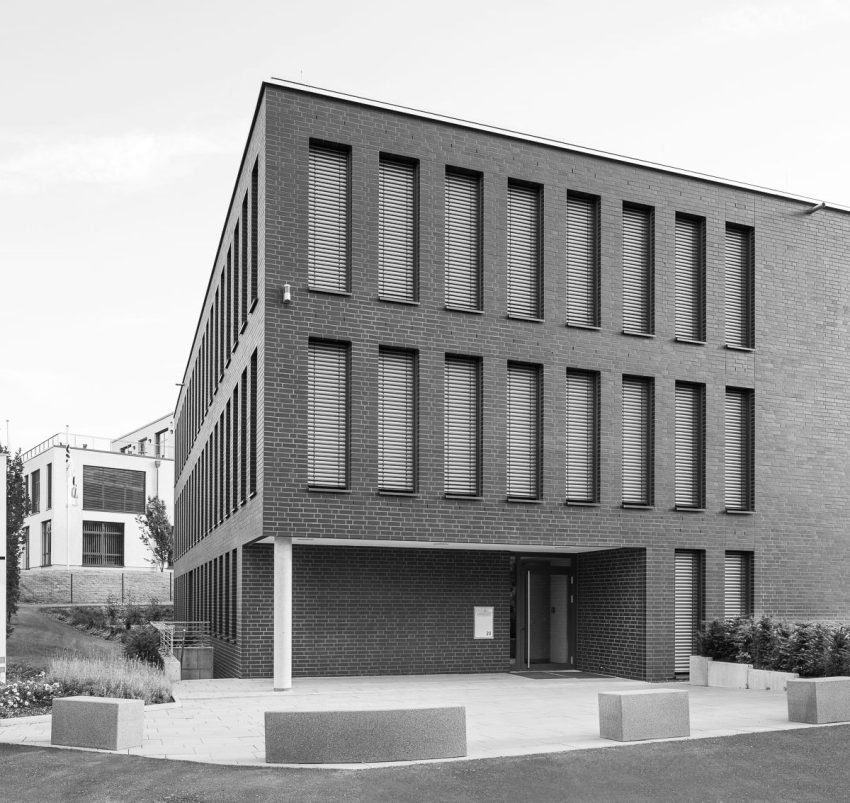 A modern building corner with concrete around it.