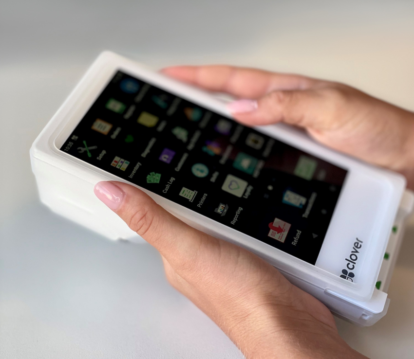 A close-up of a person holding a Clover terminal